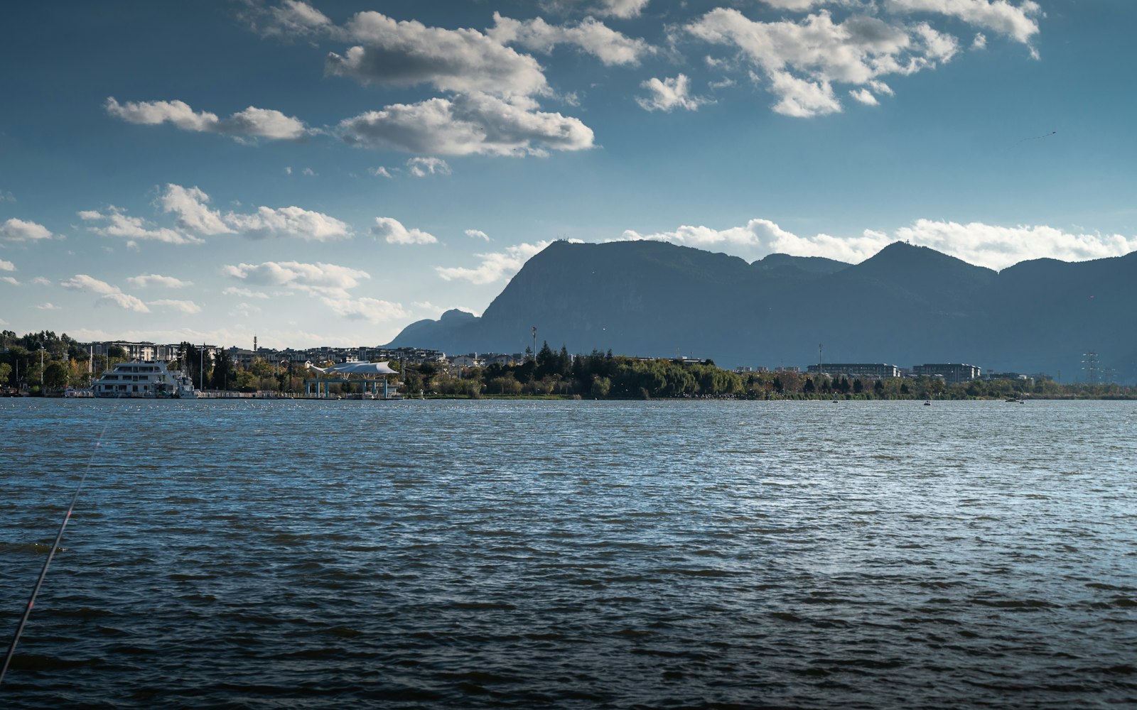Dianchi Lake in Kunming under a blue sky, with the Western Hills behind