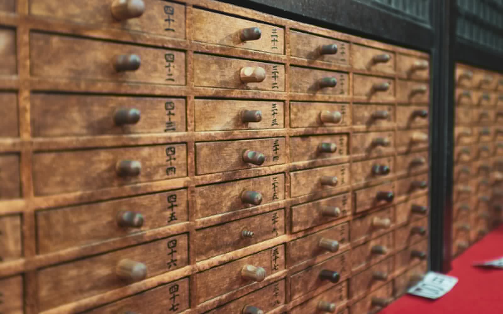 A wall of small wooden drawers in a traditional Chinese medicine dispensary