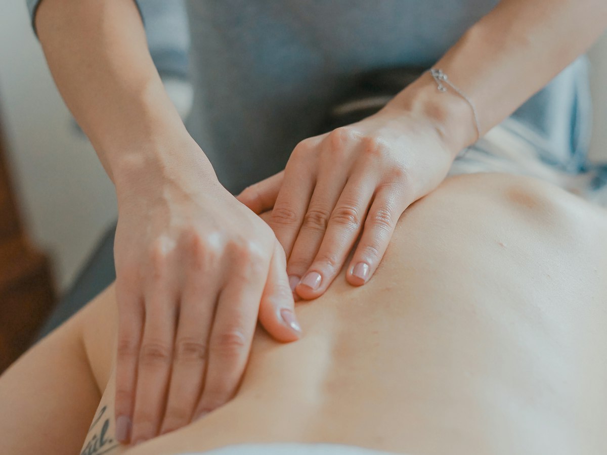 Hands giving a tuina massage on a person's back
